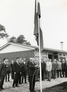 841021 Afbeelding van gedeputeerde A.C. Verhoef tijdens het hijsen van de vlag bij de opening van het uitvoeringsbureau ...